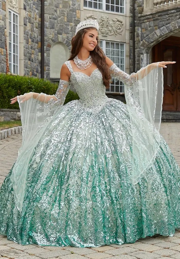 Young woman in a sparkling mint green ballgown and tiara, posing outdoors.