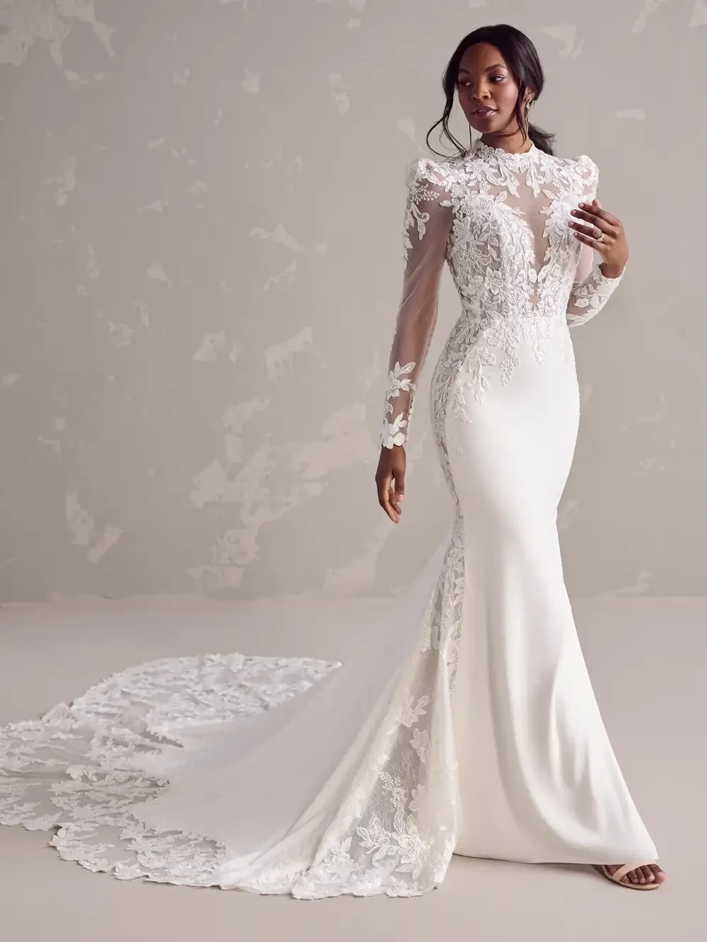 model is wearing a short sleeved gown by maggie sottero